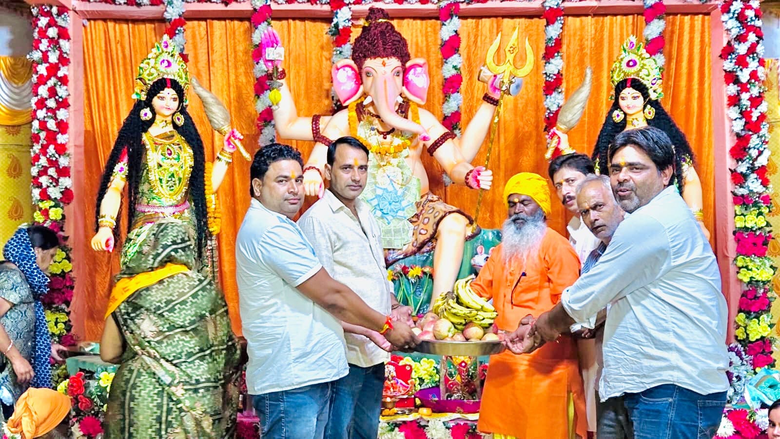 रामलीला मैदान में गणेश चतुर्थी महोत्सव में गणपति बप्पा  को भोग लगाते श्रद्धालु स्रोत संवाद