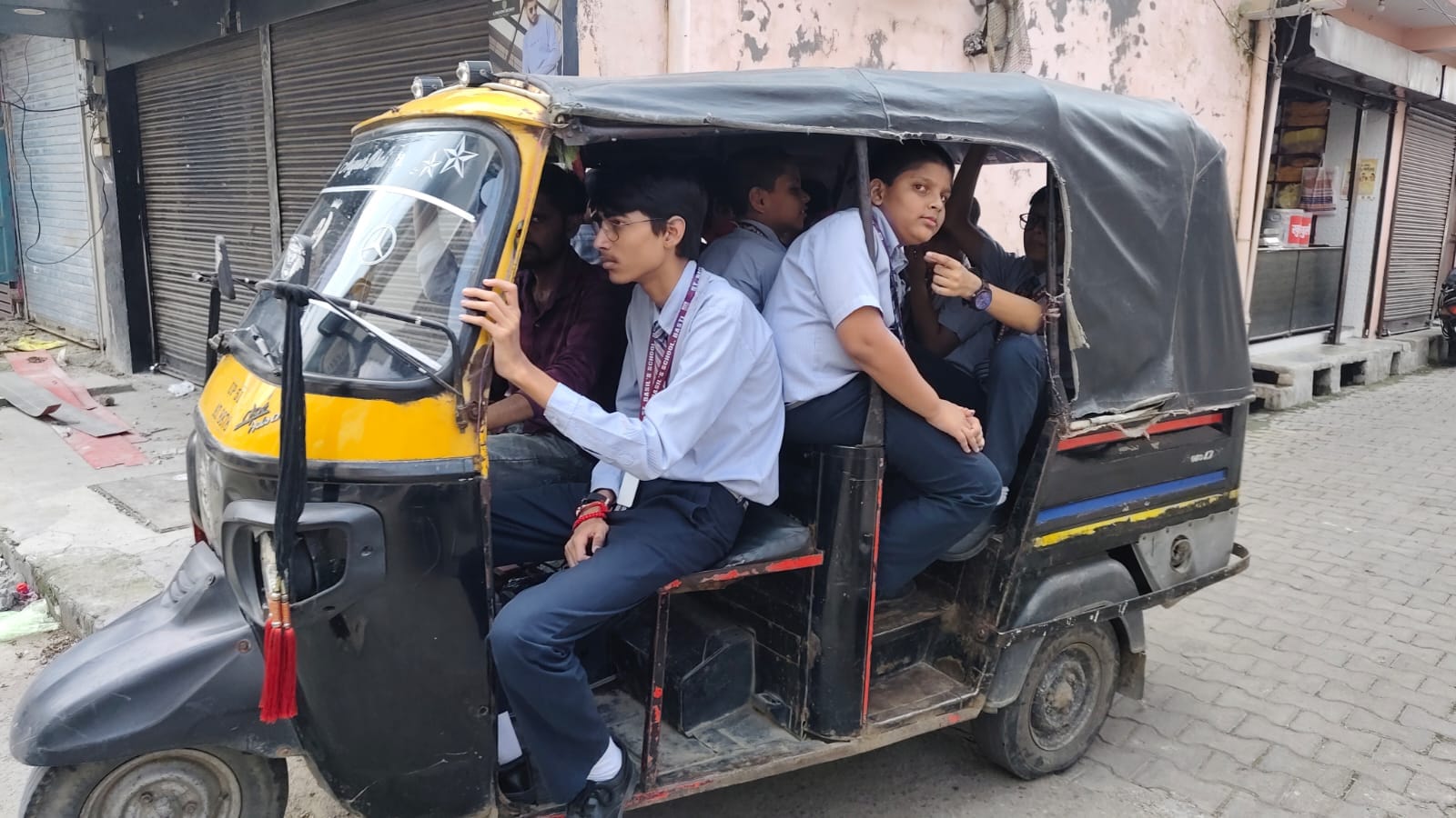आटो में ठूसकर भरे गए स्कूली बच्चों के बाहर लटक रहे हाथ व पैरसंवाद