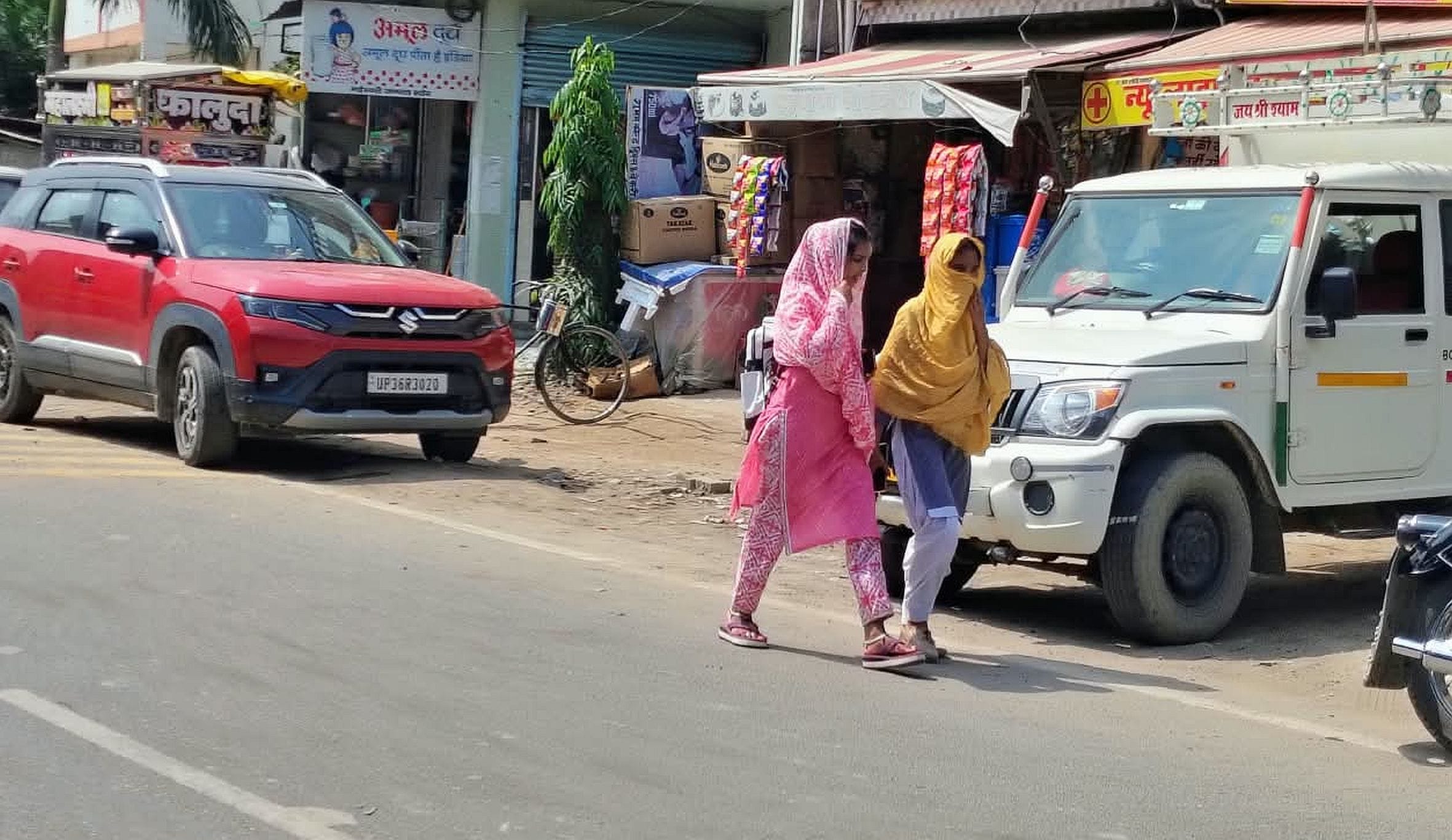 गौरीगंज बाजार में धूप से बचाव के लिए चेहरा ढक कर जाती युवती। -संवाद