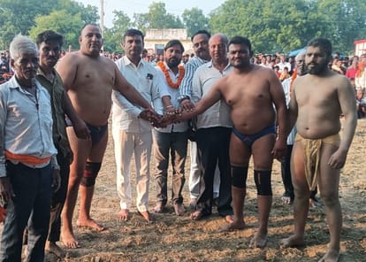पहलवानों को हाथ मिलवा कर मुकाबला शुरू कराते कमेटी पदाधिकारी। स्रोत: आयोजक