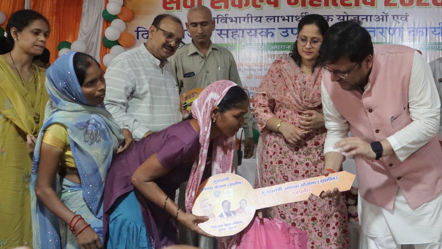 फोटो 32: दिव्यांग लाभार्थी को आवास की प्रतीकात्मक चाबी देते आबकारी मंत्री नितिन अग्रवाल, साथ मे
