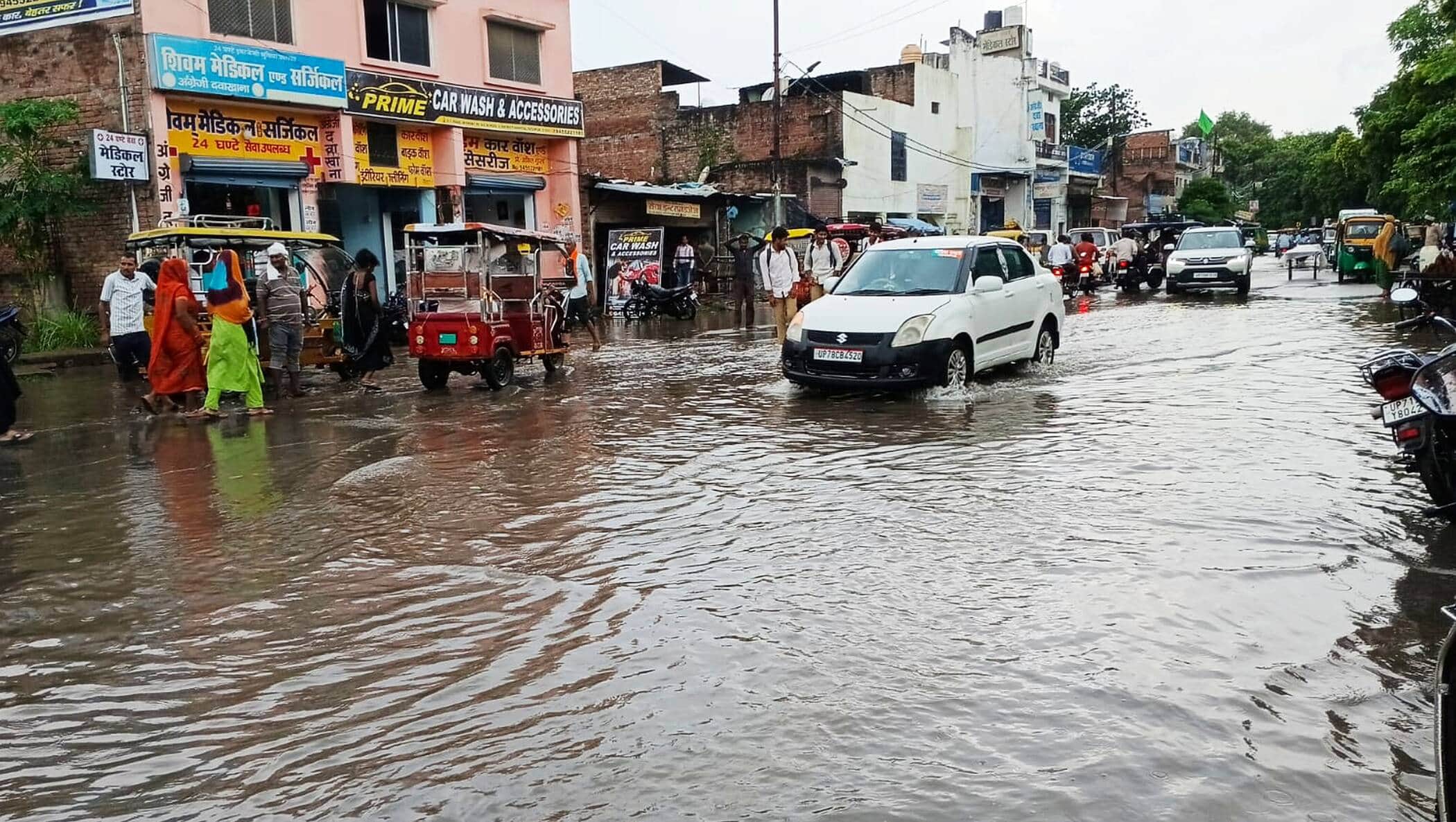 फोटो-45-जिला अस्पताल के पास सड़क पर भरे पानी से निकलते वाहन। संवाद
