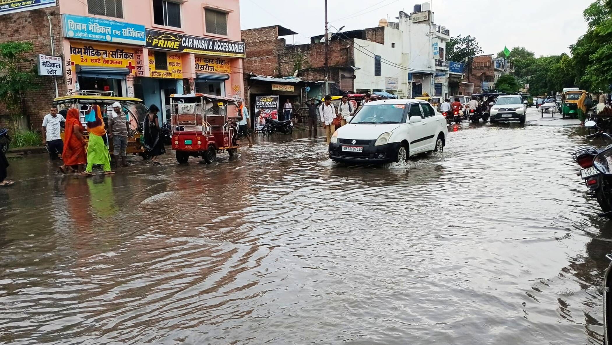 फोटो-45-जिला अस्पताल के पास सड़क पर भरे पानी से निकलते वाहन। संवाद