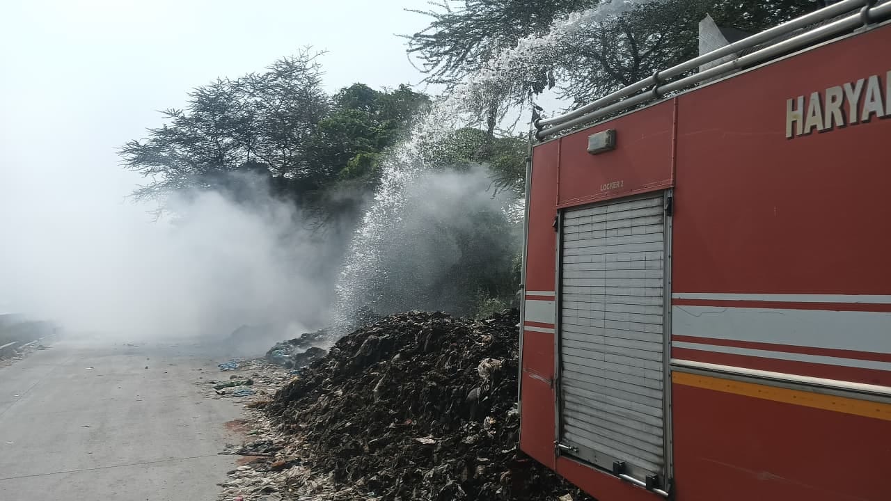 हाईवे पर कूड़े में लगी आग को बुझाते हुए दमकलकर्मी। स्तोत, अधिकारी