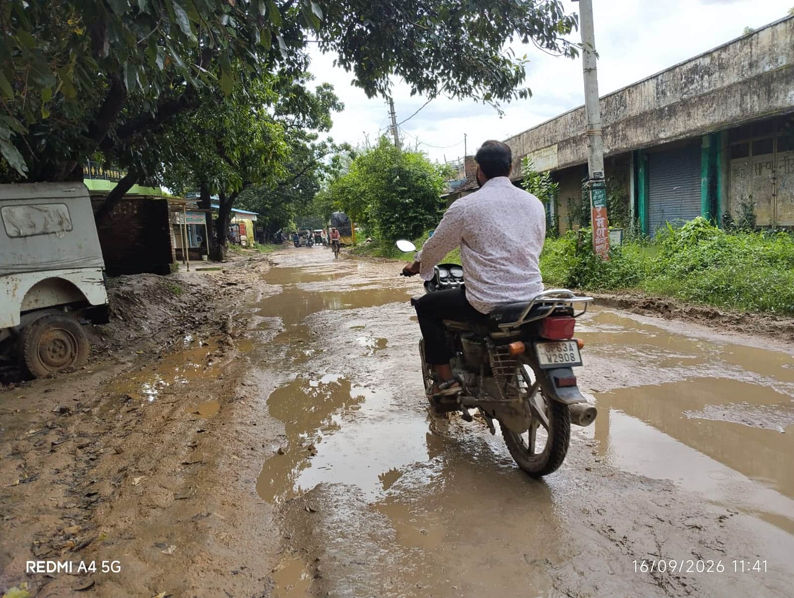 रमईपट्टी-कनौराघाट मार्ग पर अघौली के पास कीचड़ सने मार्ग पर गुजरता बाइक सवार।-संवाद।