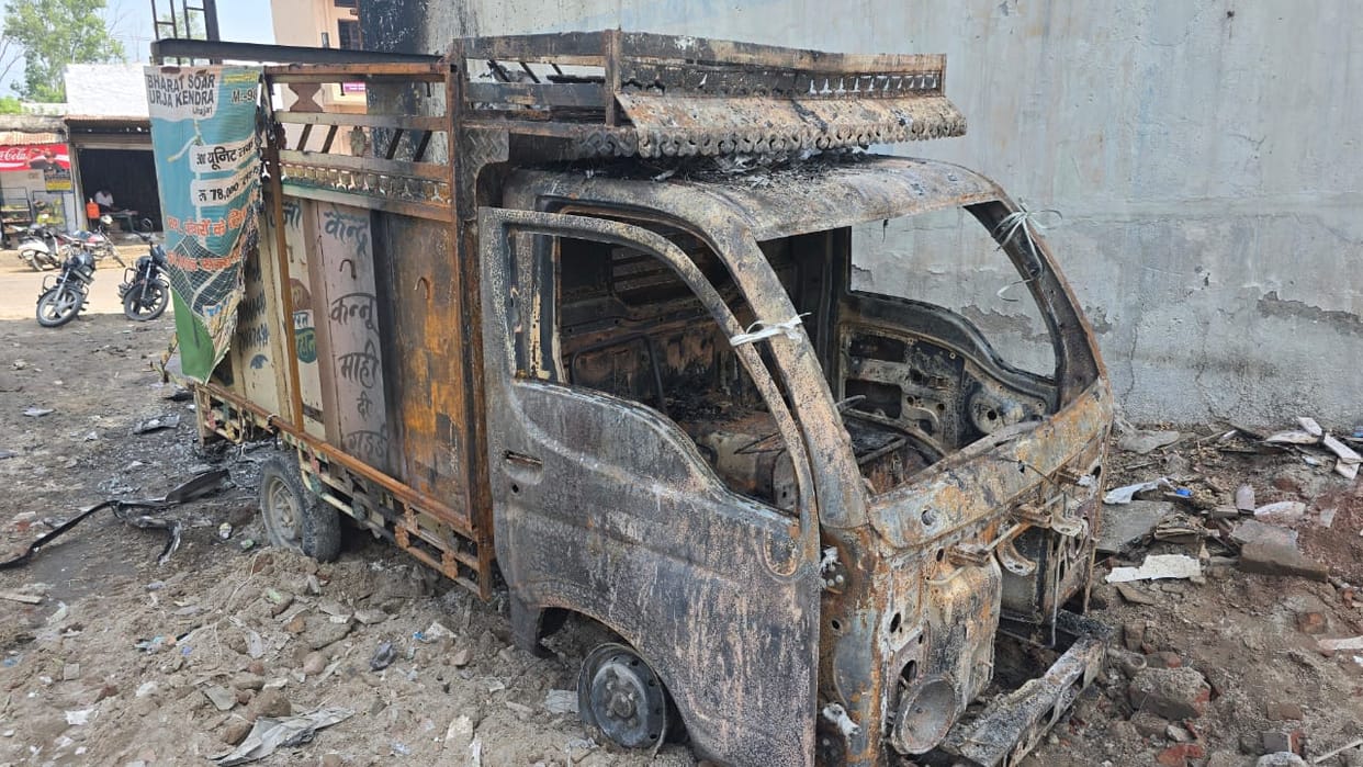 Major accident before showroom opening; exterior facade, furniture, and a parked vehicle gutted by fire.