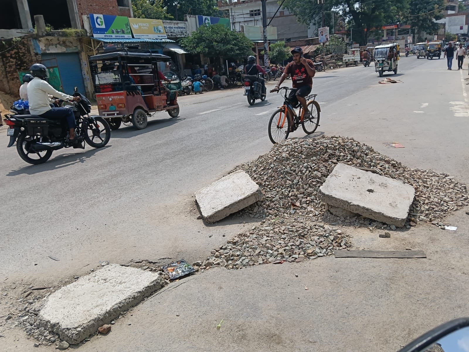 अग्रसेन चौराहे पर सड़क में बने होल के पास गिराई गई गिट्टी और गड्ढे पर रखी गई पटिया। संवाद