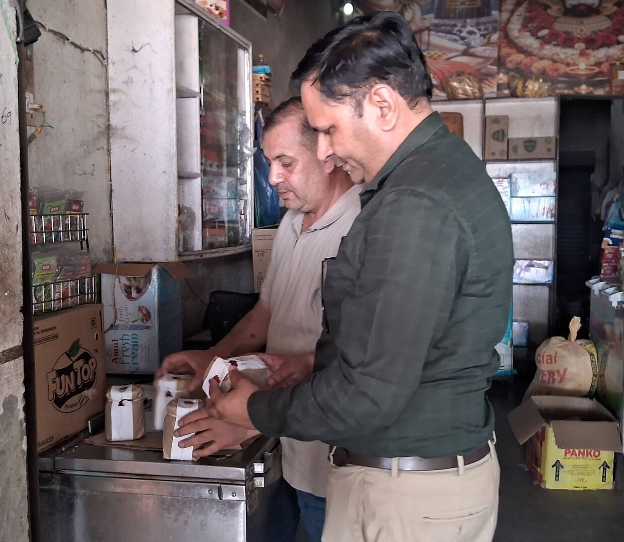 Team arrives to collect food samples; several shopkeepers pull down shutters and flee.