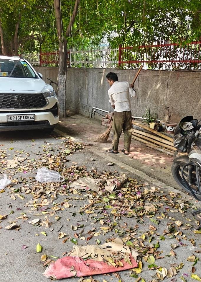 नोएडा सेंचुरी अपार्टमेंट में सफाई करते कर्मचारी।