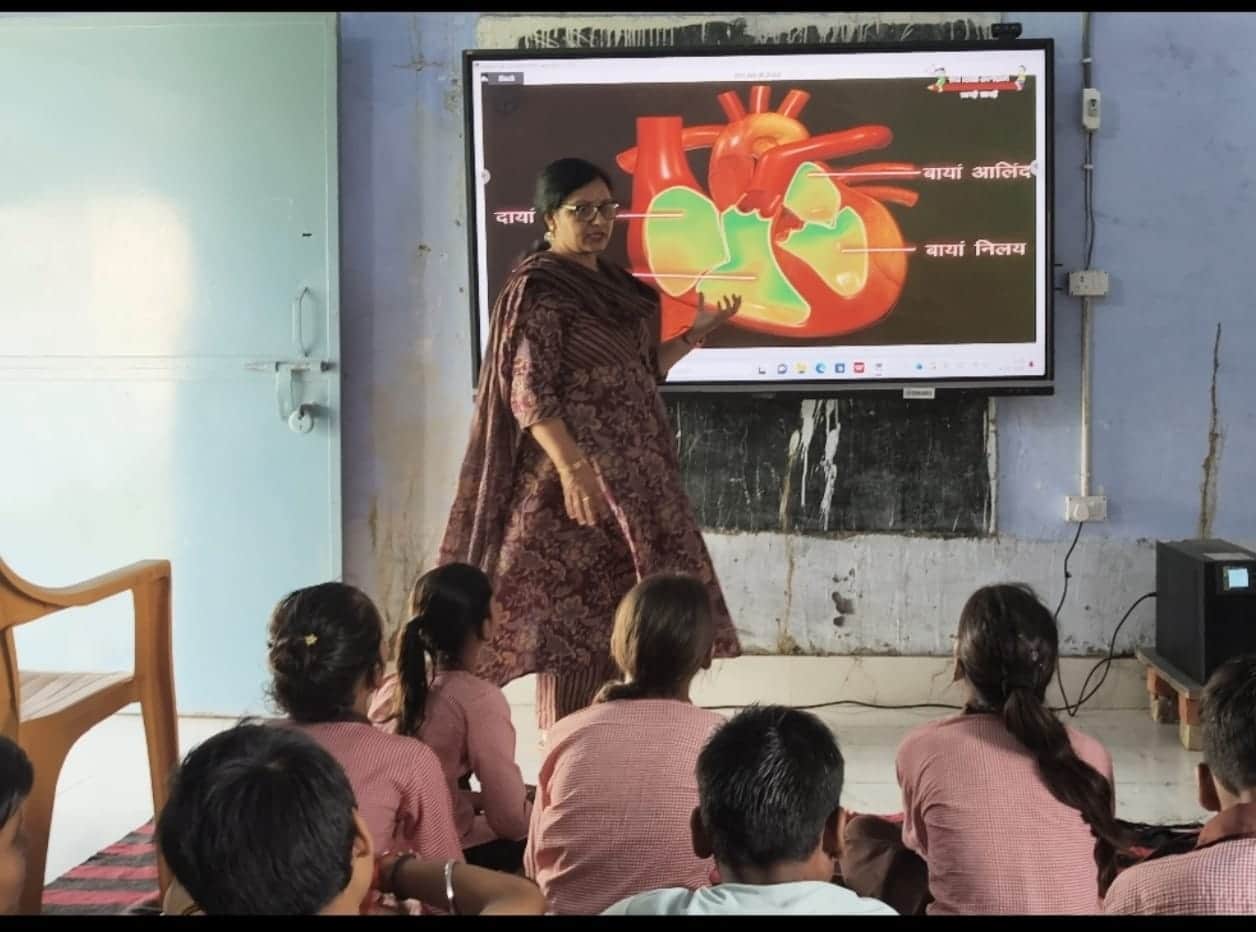 उच्च प्राथमिक विद्यालय नौगवां में स्मार्ट टीवी पर दिल के बारे में जानकारी देतीं शिक्षिका नूतन य