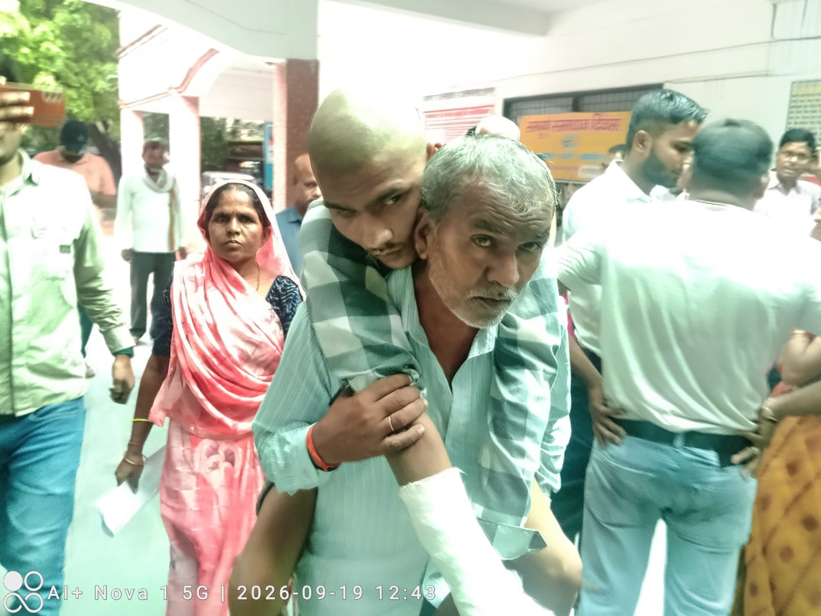 फोटो 19 एचएएमपी 20- जिलास्तरीय समाधान दिवस पर कंधे में लादकर बेटे को ले जाता पीड़ित पिता। संवाद