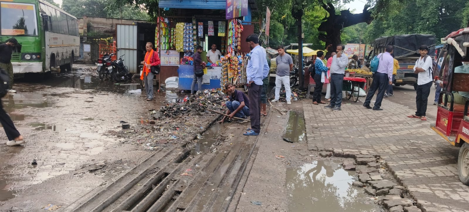 फोटो-30- बस स्टैंड के प्रवेश द्वार पर नाले की सफाई करता कर्मचारी। संवाद