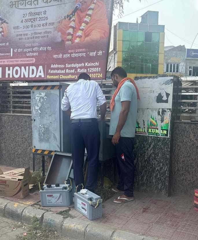 फतेहाबाद में ट्रैफिक सिग्नल के लिए बैटरी लगाते हुए कर्मचारी स्त्रोत नगर परिषद