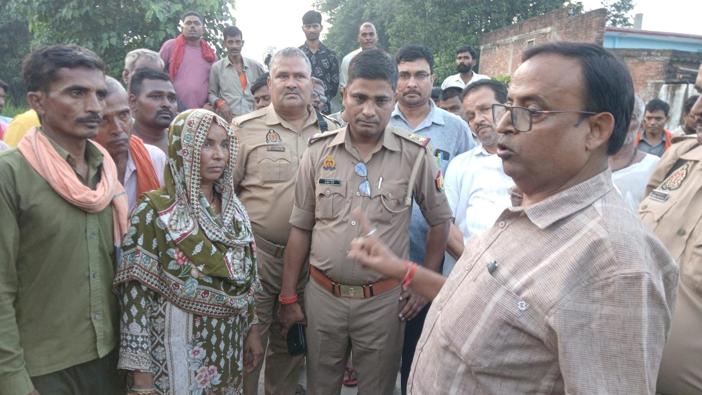 नायब तहसीलदार की गाड़ी के सामने बैठे ग्रामीण व आक्रोशित लोगों को समझाते एसडीएम।