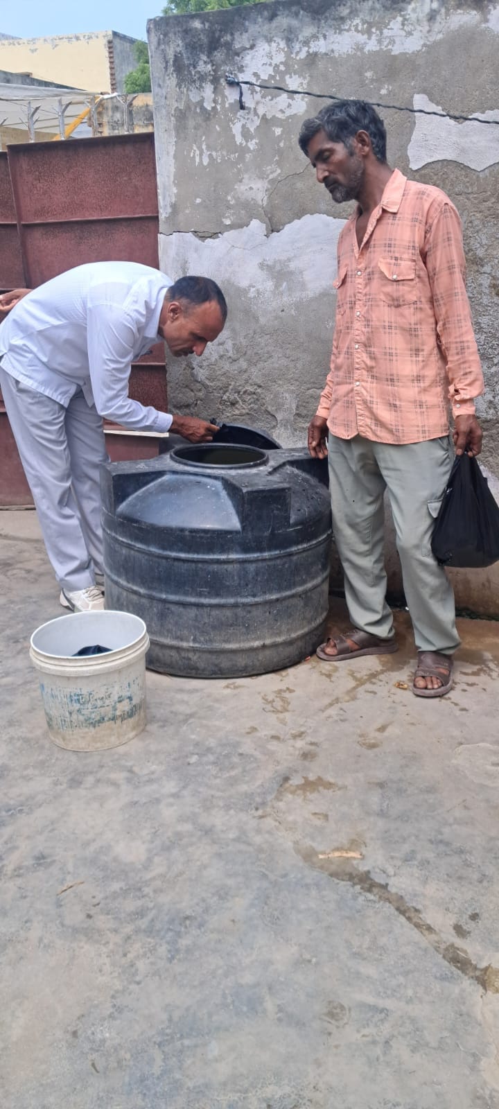 पानी की टंकी में लारवा की जांच करते हुए स्वास्थ्य विभाग के अधिकारी। 