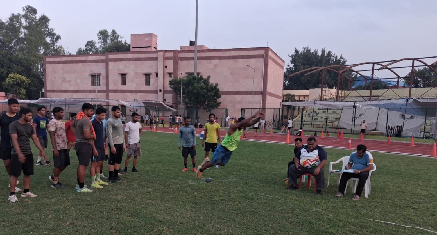 स्टेडियम में आयोजित शारीरिक दक्षता परीक्षा में भाग लेते कुश्ती खिलाड़ी