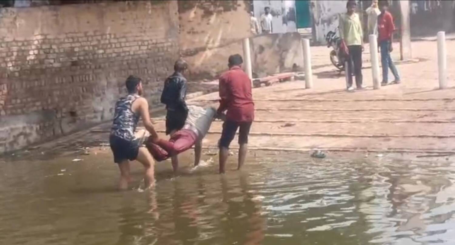फोटो - भावड़ गांव में तालाब से शव को बाहर निकालते हुए युवक। स्रोत - ग्रामीण
