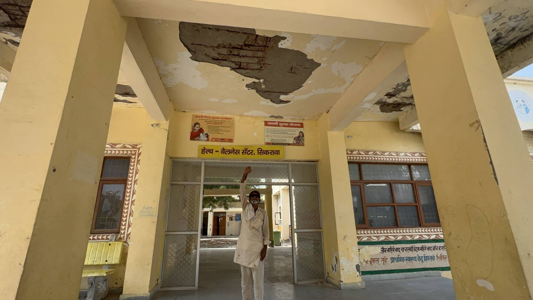 जर्जर पलस्तर और भवन की हालत दिखाते ग्रामीण।
