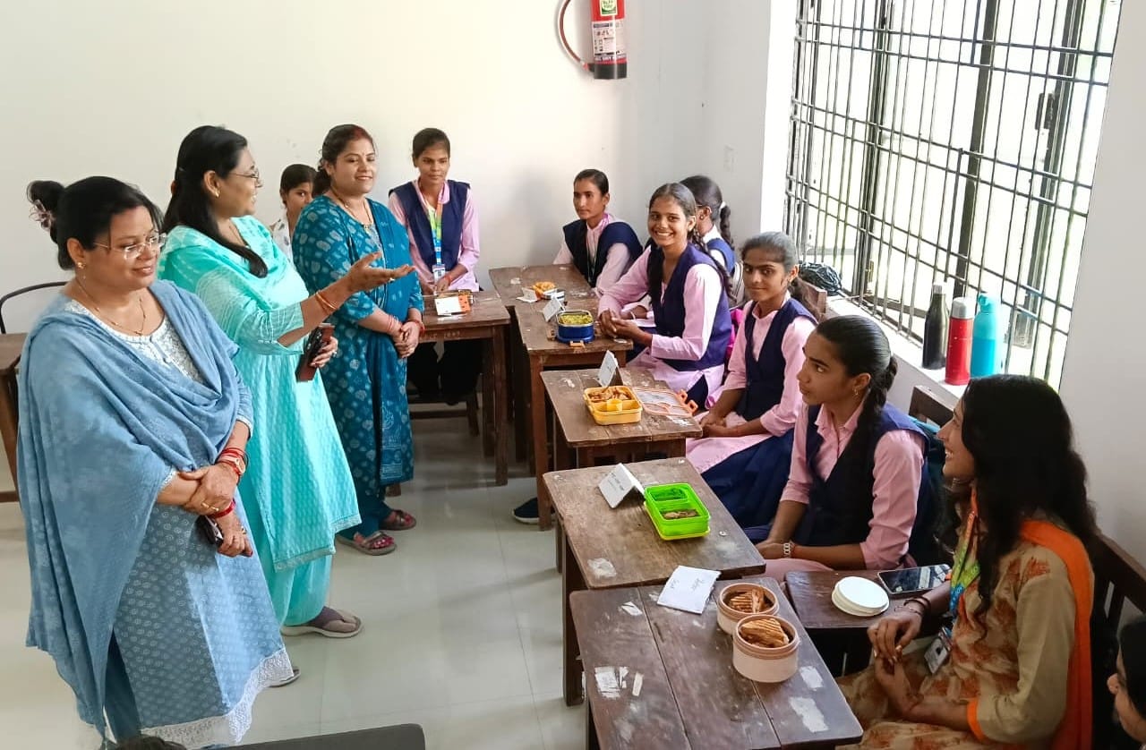 केएनयू के गृह विज्ञान विभाग में छात्राओं के व्यंजन को देखती महिला प्रोफेसर। स्रोत: विवि