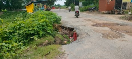 A dangerous pothole on the bridge road, filled with rainwater.