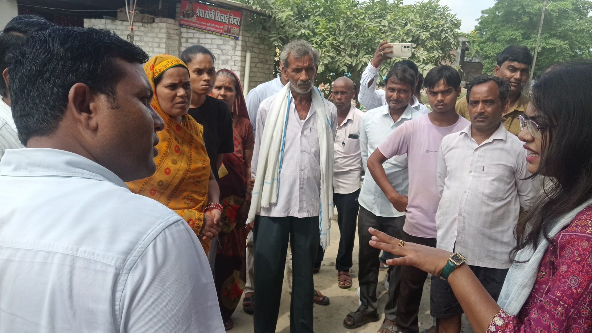 बरियावन-किछौछा मार्ग पर मकान-दुकान टूटने के बाद ग्रामीणों से बात करती तहसीलदार दिव्या भारती वर्