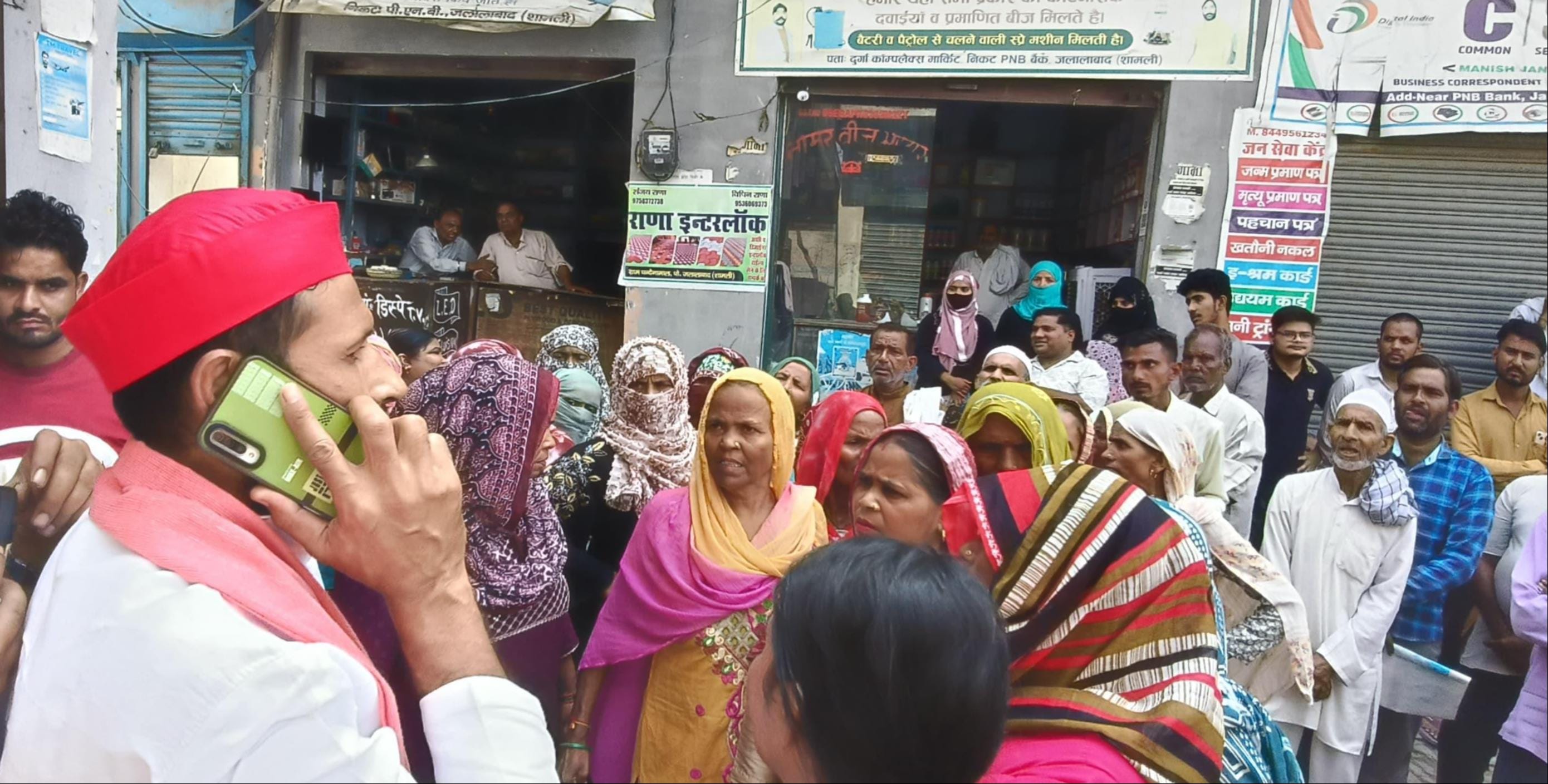 जलालाबाद के पंजाब नेशनल बैंक शाखा के बाहर सपा नेता का घेराव कर हंगामा करती महिलाएं। ग्रामीण