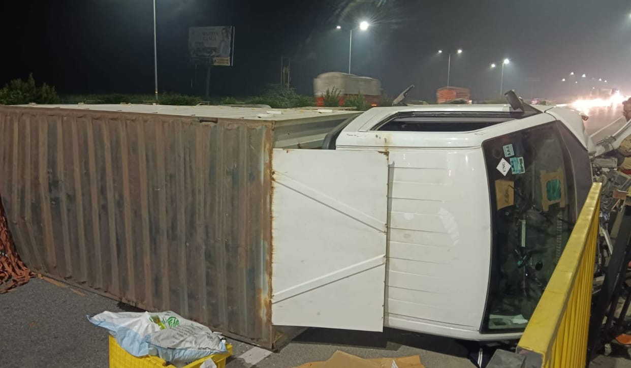 Canter overturns and crashes into railing on highway; driver injured