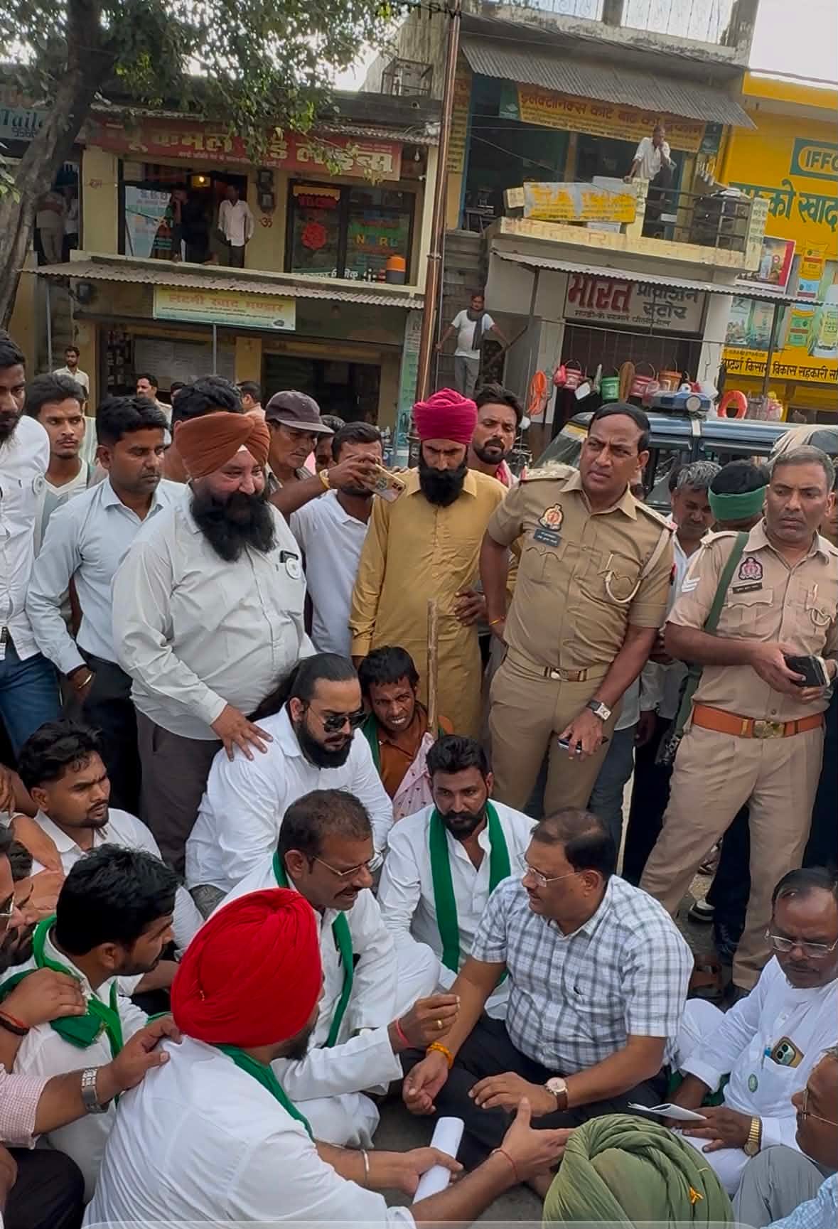 मंडी गेट पर जाम लगाए बैठे किसान नेताओं से बातचीत करते सिटी मजिस्ट्रेट। संवाद