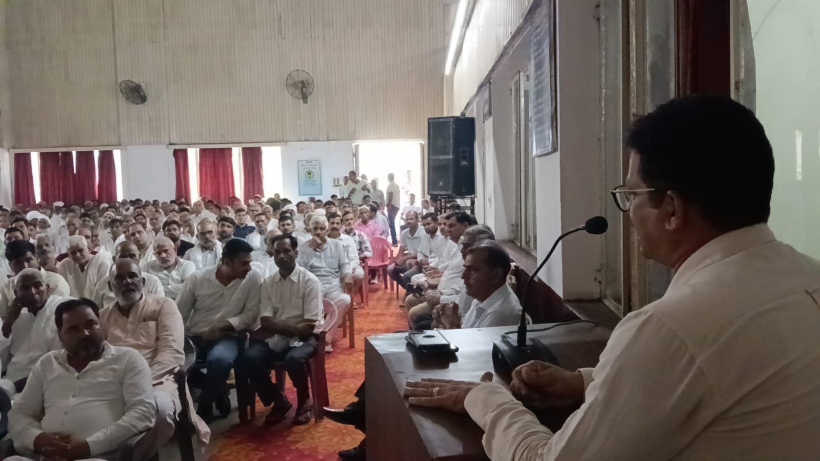 दौराला - सहकारी गन्ना समिति में आयोजित बैठक में किसानों को जानकारी देते अधिकारी। स्रोत : स्वयं