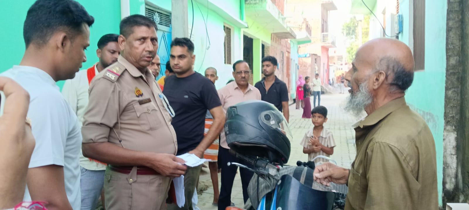 बाइक सवार आरोपी से पूछताछ करती पुलिस व मौके पर मौजूद मोहल्ले के लोग। संवाद