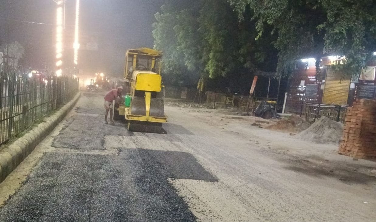 गड्ढों की पैचिंग के बाद रोलर से बराबर करते कर्मी। स्रोत: पाठक।