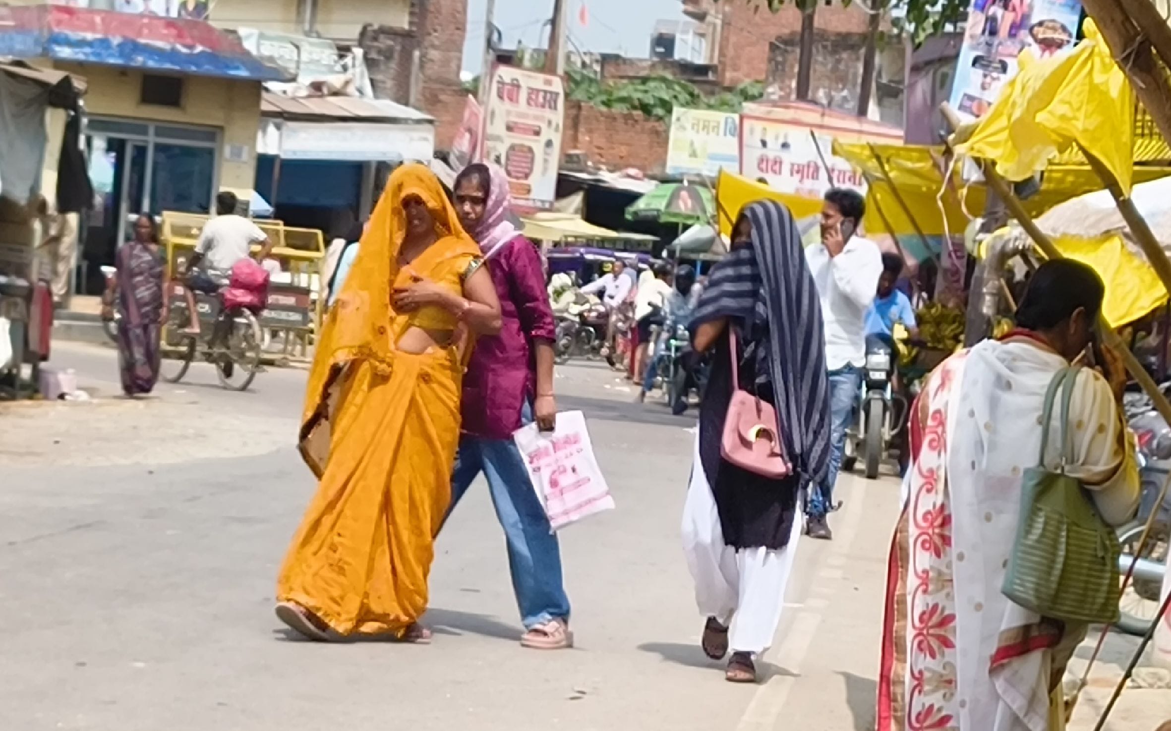  गौरीगंज शहर में धूप से बचाव के लिए सिर ढक कर जाती महिला व युवतियां। -संवाद