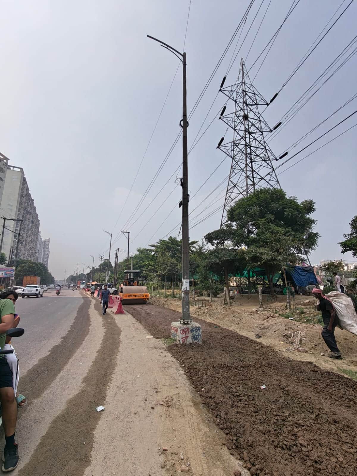 Road widening work begins; poles standing in the middle remain unremoved.