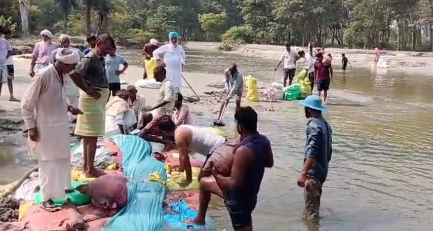 जलीलपुर क्षेत्र में श्रमदान कर गंगा पर बालू बोरे का बंधा बनाते गांववासी फोटो स्रोत ग्रामीण