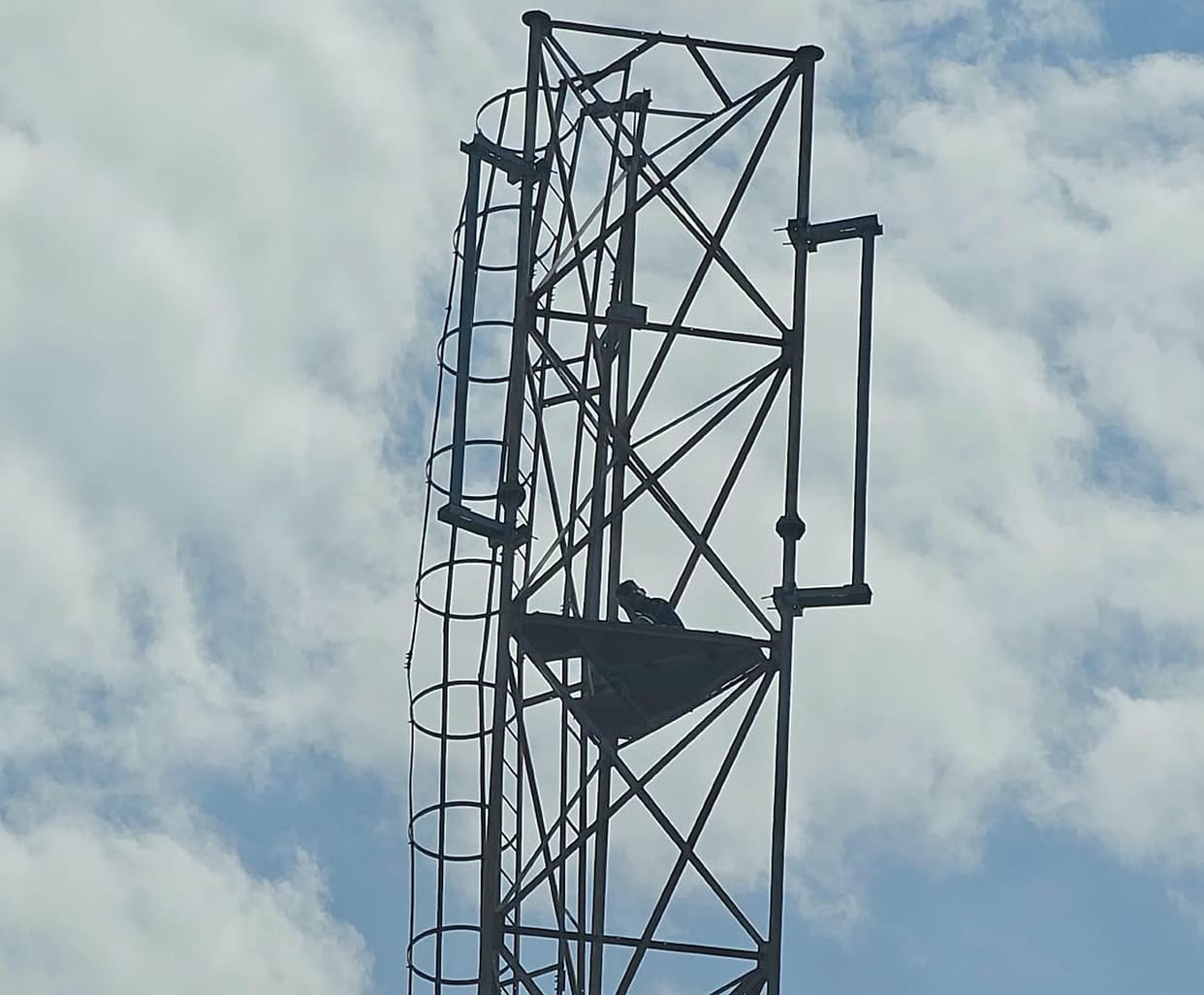 Youth stayed atop mobile tower for 10 hours; climbed down after CO's persuasion.