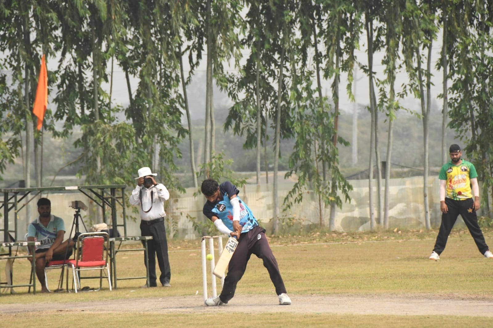 क्रिकेट प्रतियोगिता में शाॅट मारता खिलाड़ी। संवाद