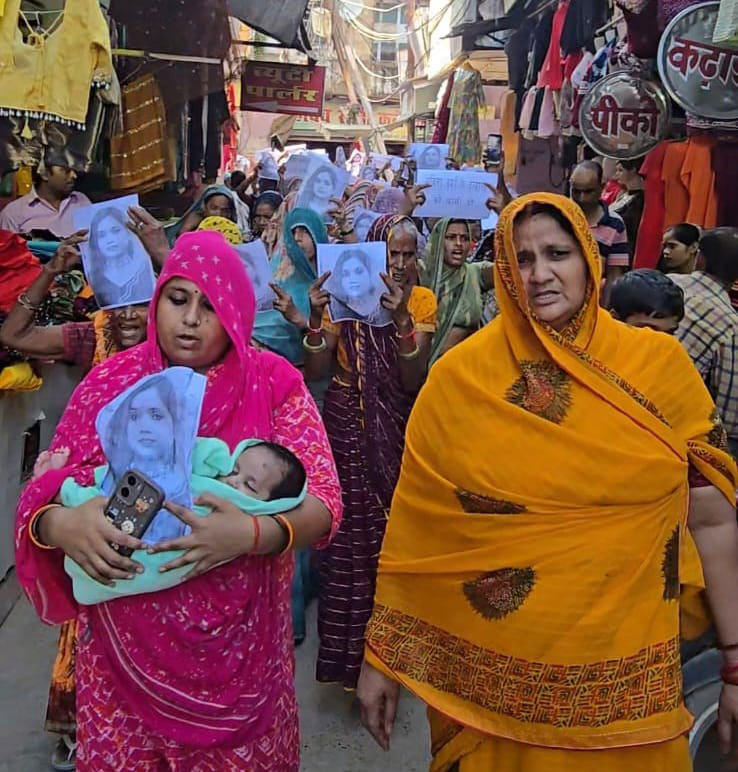 A two-month-old infant in her lap, a poster of a poem in her hand.