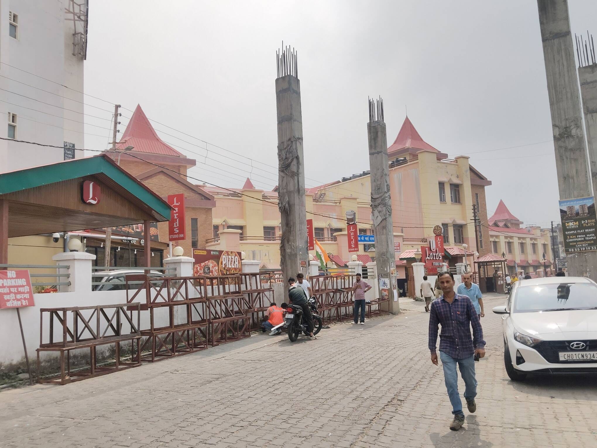 भव्य प्रवेश द्वार बनाने के लिए पिलरों  के साथ रखा हुआ शटरिंग का सामान