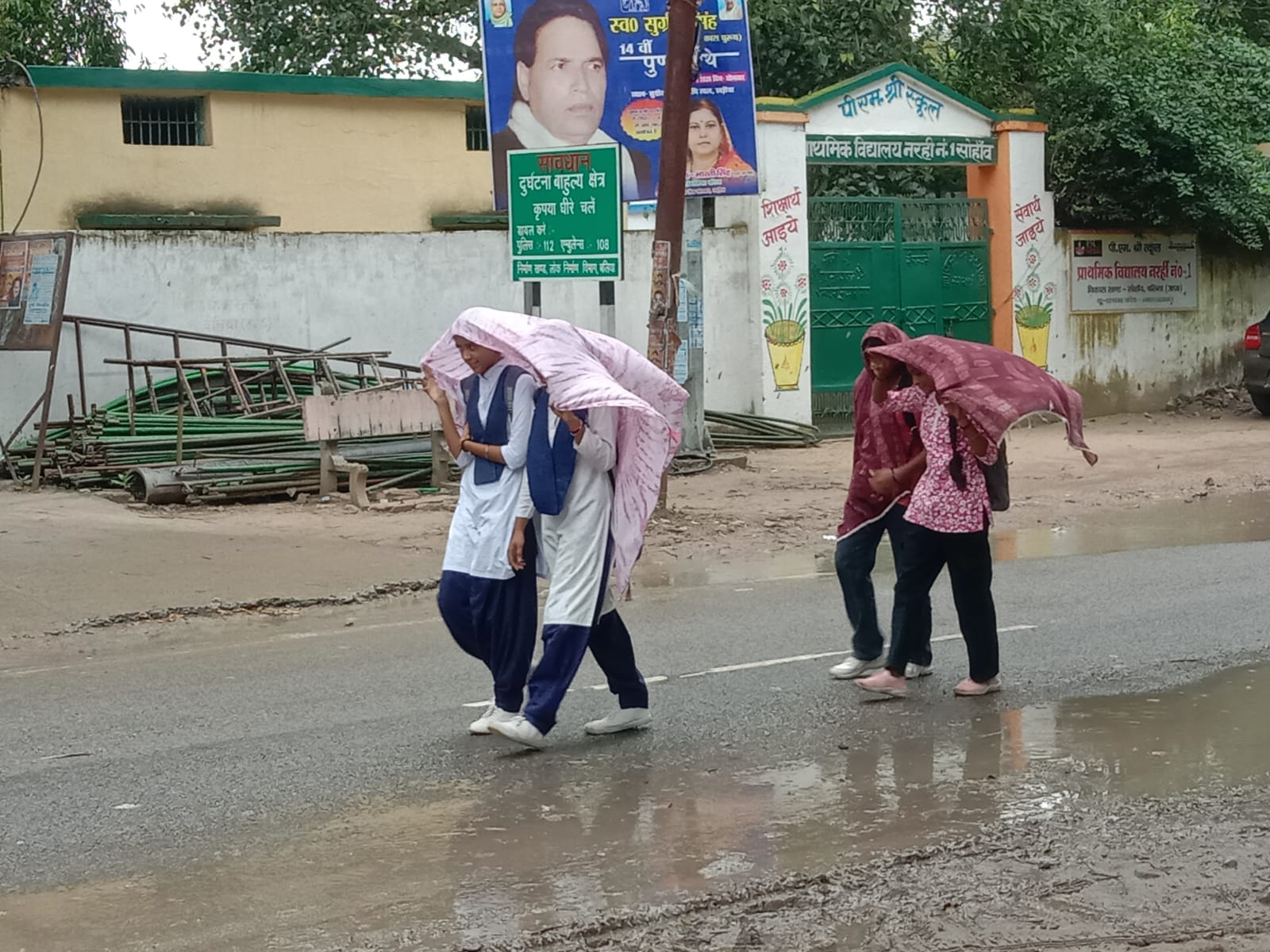 बारिश में भींगते हुए अपने गंतव्य को जाती छात्राएं। संवाद
