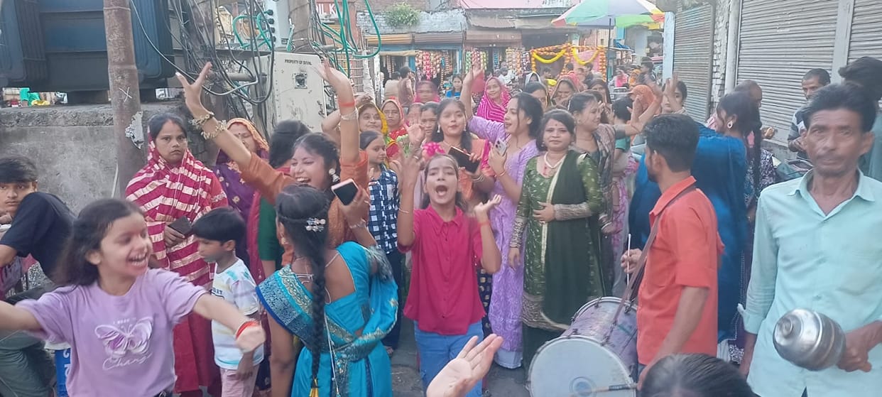 Ganesh idols taken out for immersion; abeer and gulal fill the air.