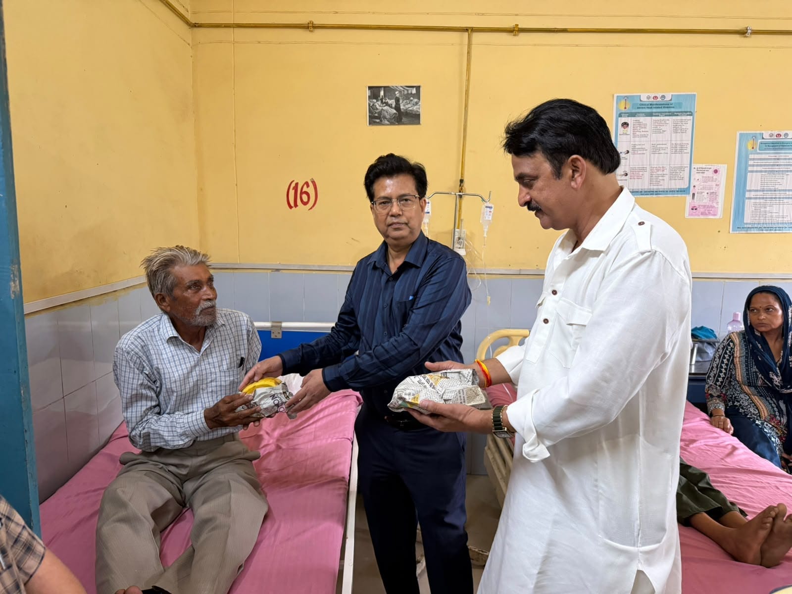 जटिया चिकित्सालय में मरीज को फल वितरित करते सीएमओ व डिप्लोमा फार्मासिस्ट एसोसिएशन के अध्यक्ष। स