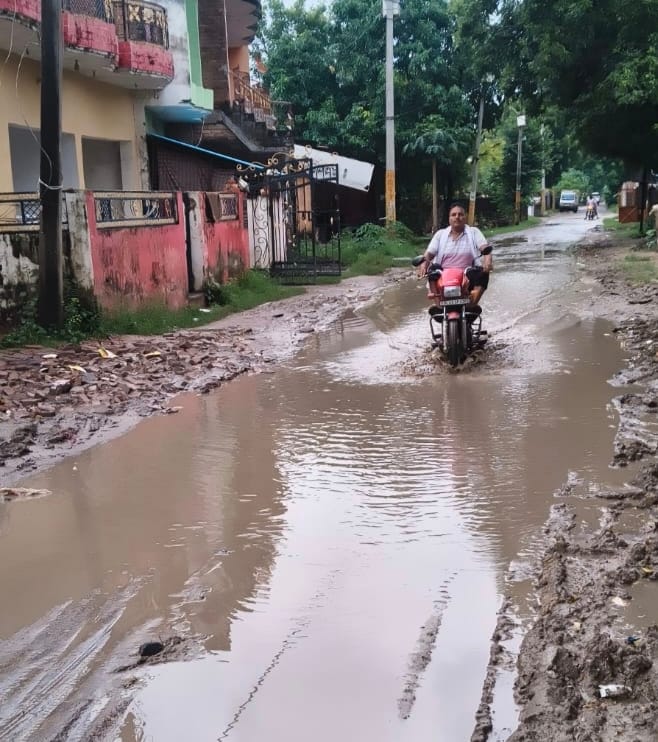 Road lost amidst potholes; commuters in distress due to water and mud