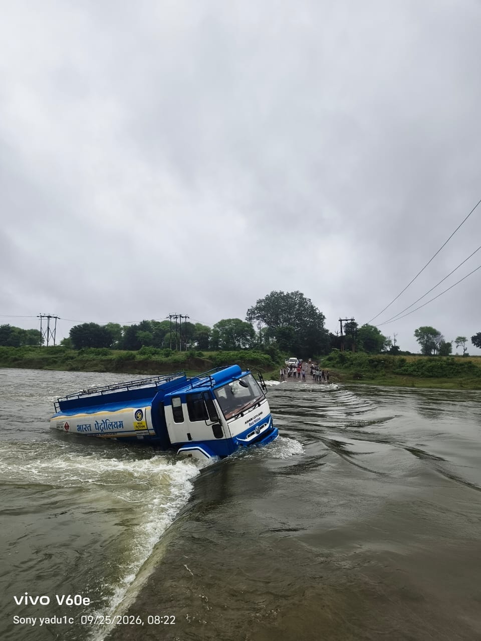 Oil tanker narrowly escapes being swept away by strong currents on bridge; driver saves his life by jumping out.