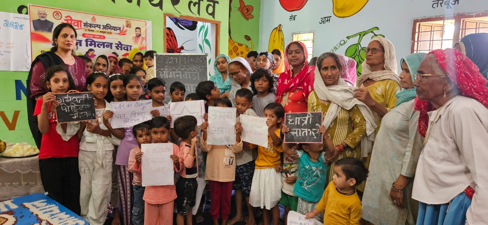 आंगनबाड़ी केंद्र में आयोजित कार्यक्रम में भाग लेते बच्चे व महिलाएं। प्रशासन