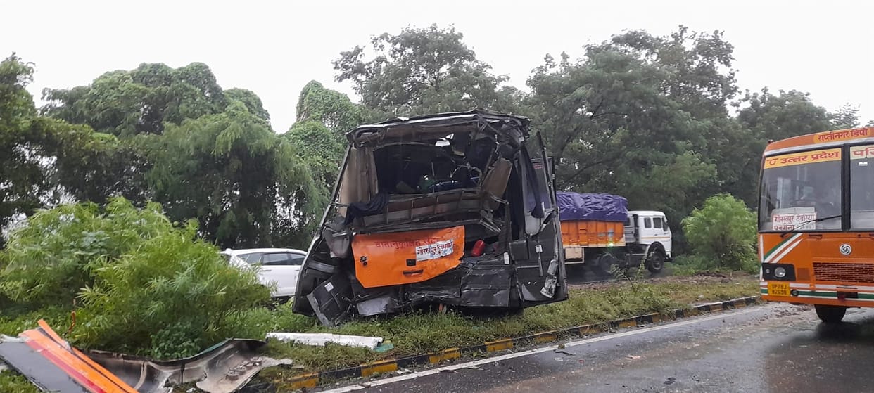 Truck collides with bus; driver and helper injured, passengers safe.