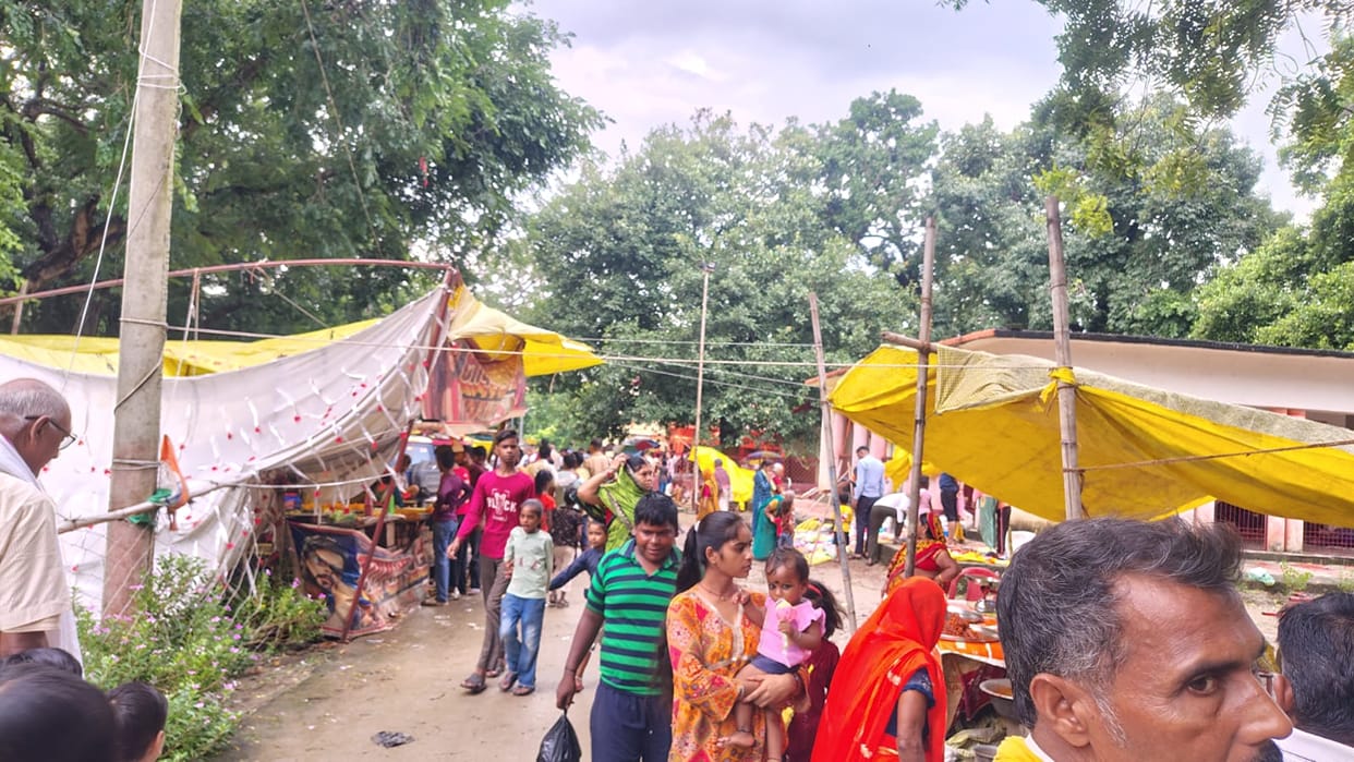 Women perform ritual baths and prayers on Bhadrapada Purnima; fair buzzes with activity.