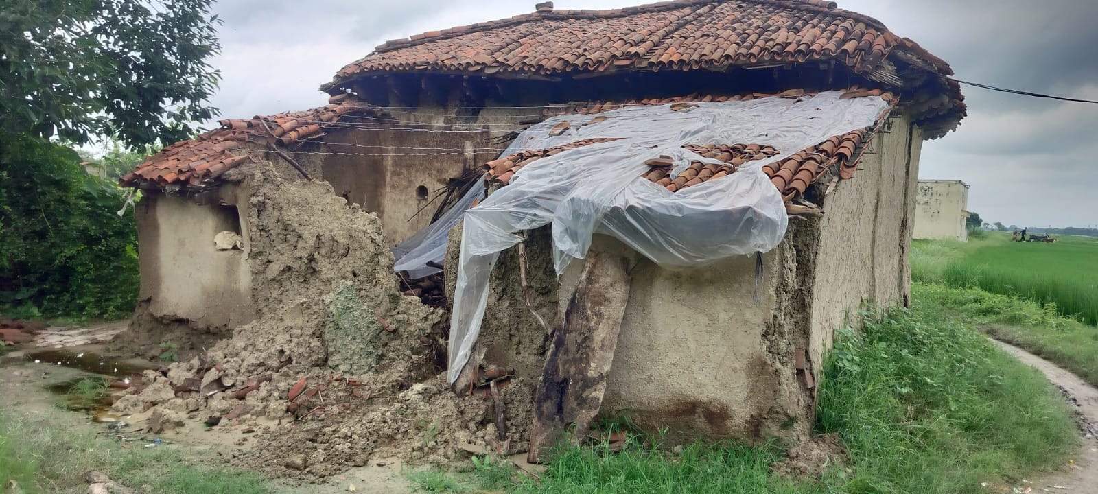 मछलीशहर तहसील के हटिया गांव में वर्षा के चलते गिरा कच्चा मकान। ग्रामीण