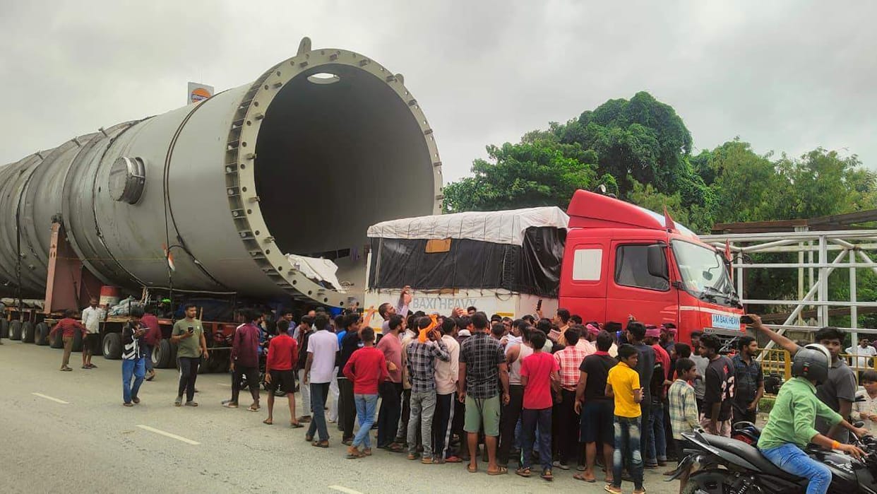 Crowd gathers on the highway to see a truck with 308 wheels.
