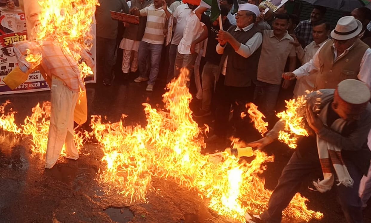 Fire catches on the jacket of an activist burning an effigy.