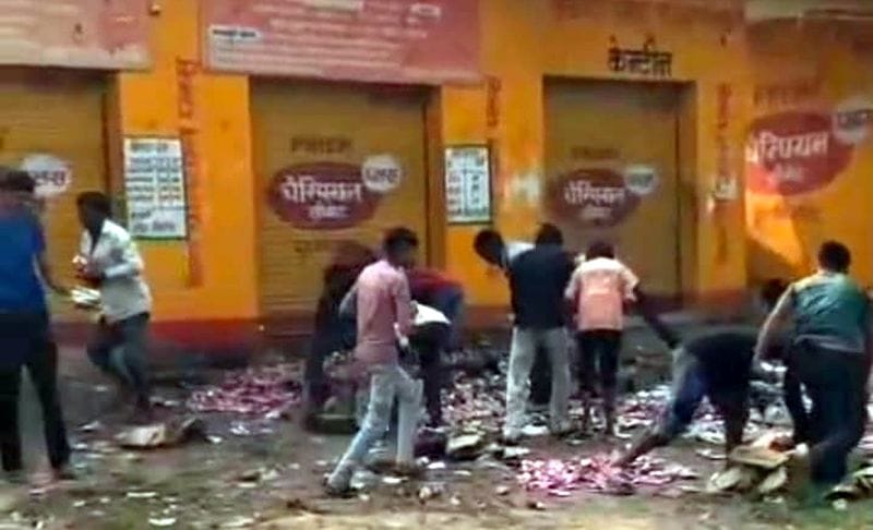 Women vandalized a liquor shop and crushed quarter-bottles underfoot.